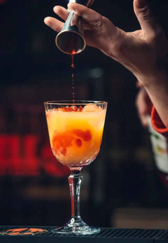 Drink autoral servido em copo baixo, com fruta do Cerrado e ervas frescas